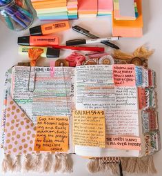 an open bible with markers, pens, and other crafting supplies laid out next to it