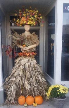 a scarecrow made out of hay and pumpkins