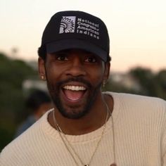 a man wearing a hat and smiling at the camera