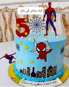 a spiderman themed birthday cake with the number five on top and two figures in the middle