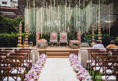 an outdoor ceremony setup with chairs and flowers