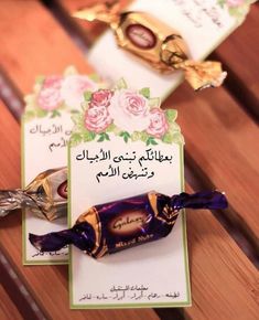 there are two chocolates on the table with an arabic greeting card in front of them