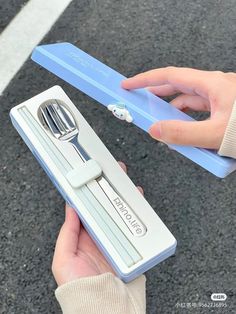 a person holding a blue and white toothbrush in their hand