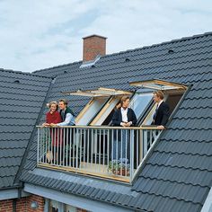 several people standing on the balcony of a house