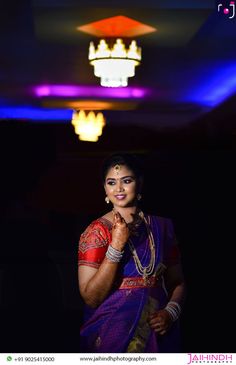 a woman in a purple sari posing for the camera with her hand on her chin