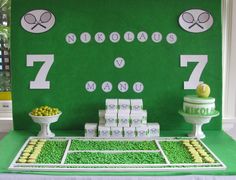 a table topped with lots of cakes and desserts next to a green wall covered in numbers