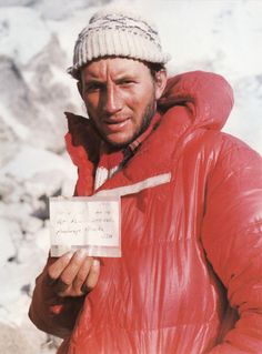 a man in a red jacket holding a piece of paper