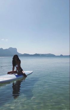 a woman sitting on a surfboard in the water