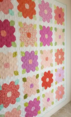 a quilted wall hanging with flowers on it