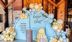 a winnie the pooh birthday party with balloons and decorations on display in a barn