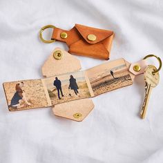 two keychains with pictures on them are laying next to a couple's keys