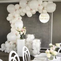 white balloons and flowers are on the table