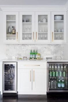 a kitchen with white cabinets and marble counter tops, stainless steel dishwasher and refrigerator