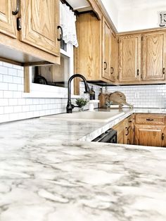 a kitchen with marble counter tops and wooden cabinets