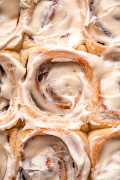 cinnamon rolls with icing sitting on top of each other