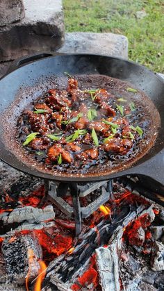 a pan filled with food sitting on top of a fire