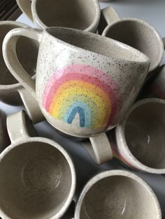 there are many cups that have been made to look like they are painted with a rainbow