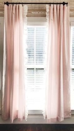 pink curtains hanging in front of a window