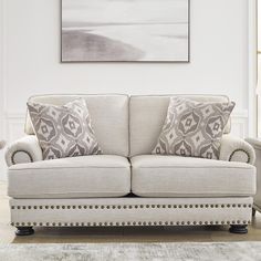 a living room with a couch, chair and rug in front of a painting on the wall