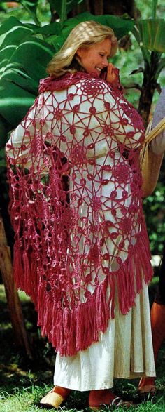 a woman wearing a crocheted shawl in the woods