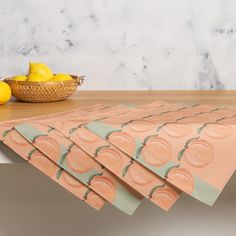 four pieces of paper sitting on top of a table next to lemons and a basket