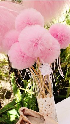 a vase filled with pink pom - poms on top of a table