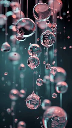 many bubbles floating in the air with water droplets hanging from it's sides and on top