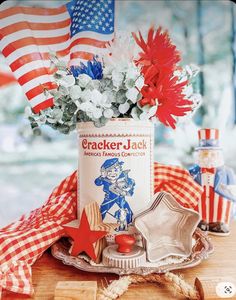 an old tin can with flowers in it on a table next to some patriotic decorations