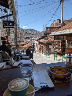 a table with plates and cups on it in front of an old fashioned storefront