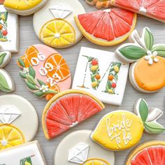 some decorated cookies are on a table with oranges, lemons and limes