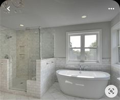 a large white bath tub sitting next to a window