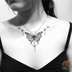 a woman's chest with a butterfly tattoo on the back of her neck,