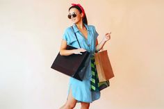 a woman in sunglasses holding shopping bags and smiling