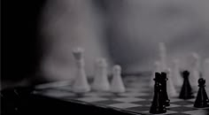 a black and white photo of chess pieces