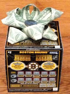 a boston hockey jersey wrapped in dollar bills on top of a box with instructions for how to fold it