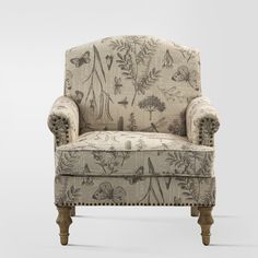 an upholstered chair with flowers and butterflies on the back, sitting in front of a white background