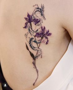 a woman's lower back tattoo with purple flowers