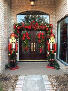 two wooden nutcrackers are standing in front of a door decorated for christmas