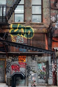 an old building with graffiti on it and stairs leading up to the second story door