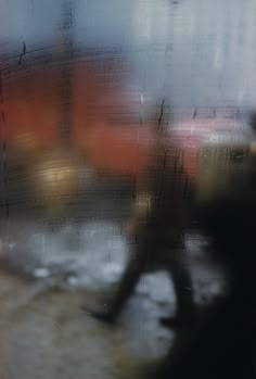 a blurry photo of a person walking in the rain