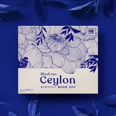 a box of ceylon tea surrounded by leaves on a blue background with the words black tea written in japanese