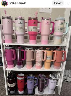 there are many different colored cups on the shelf