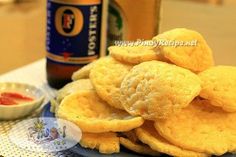 there are some fried food on the plate next to a bottle of beer and a bowl of ketchup