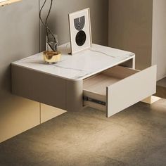 a white desk with an open drawer underneath it in a room that has beige walls and flooring