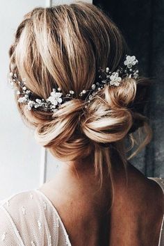 a woman with blonde hair wearing a white dress and a flower headpiece in her hair