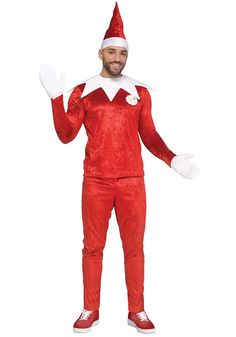 a man dressed in an elf costume standing with his hands out and smiling at the camera