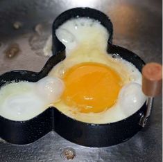 an egg frying pan with two eggs in it on top of a metal surface