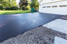 an asphalt driveway in front of a house