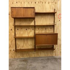 three wooden shelves with peg holes in the middle and one shelf on the other side