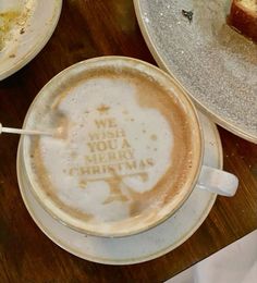 a cup of cappuccino with the words we wish you a merry christmas on it